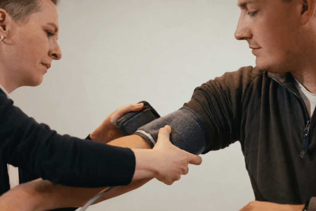 Een preventiemedewerker meet de bloeddruk van een medewerker tijdens een preventief medisch onderzoek (PMO)
